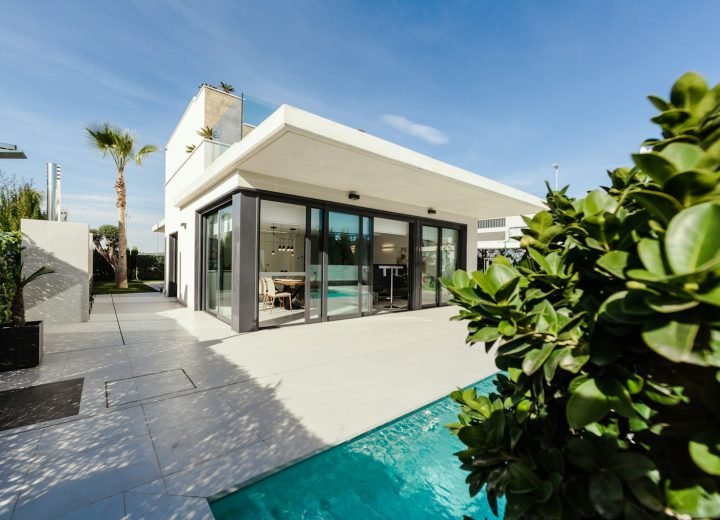 White villa with a pool and garden